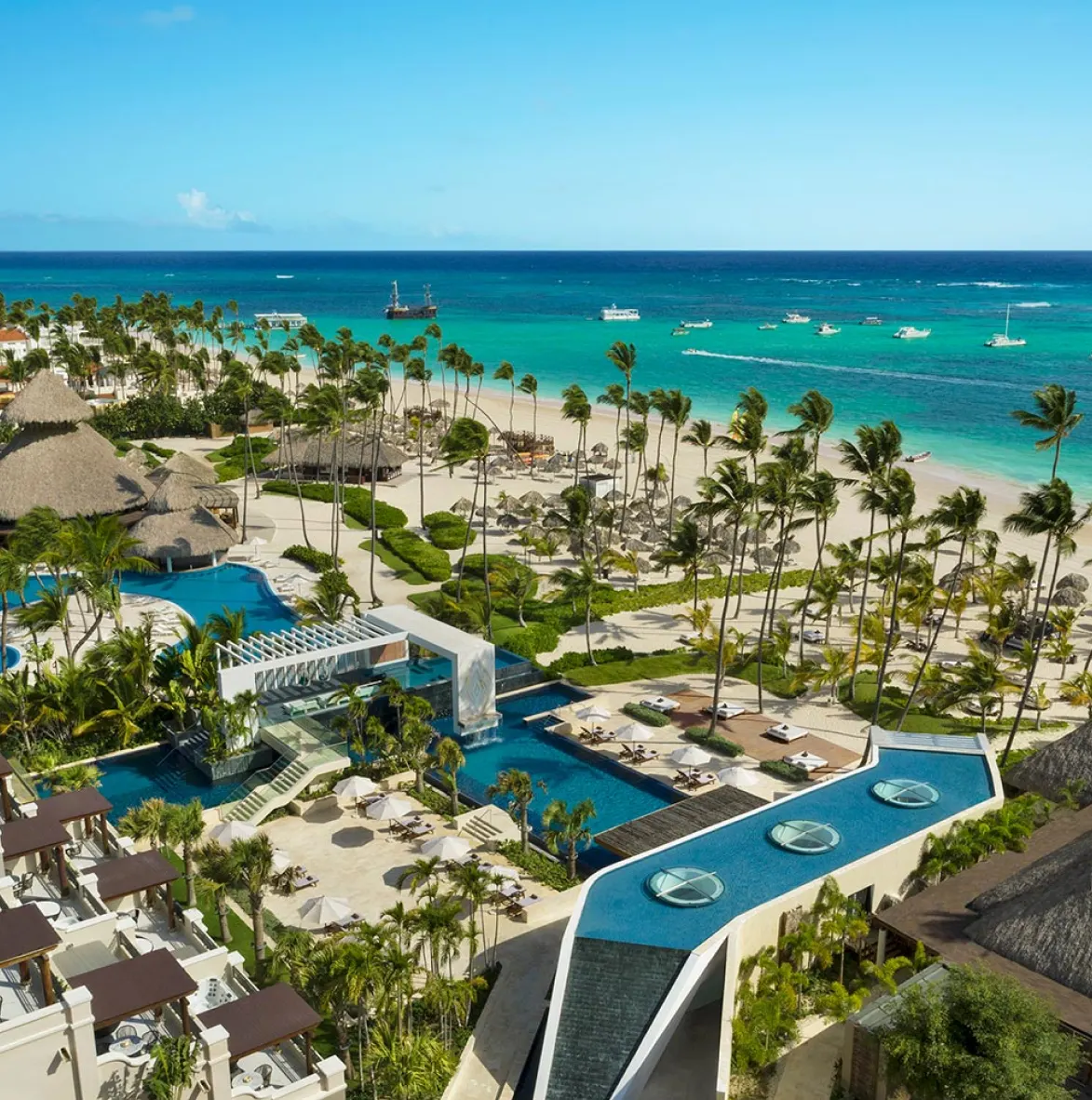 Vista aérea de un resort frente a una playa de aguas turquesas en la costa este